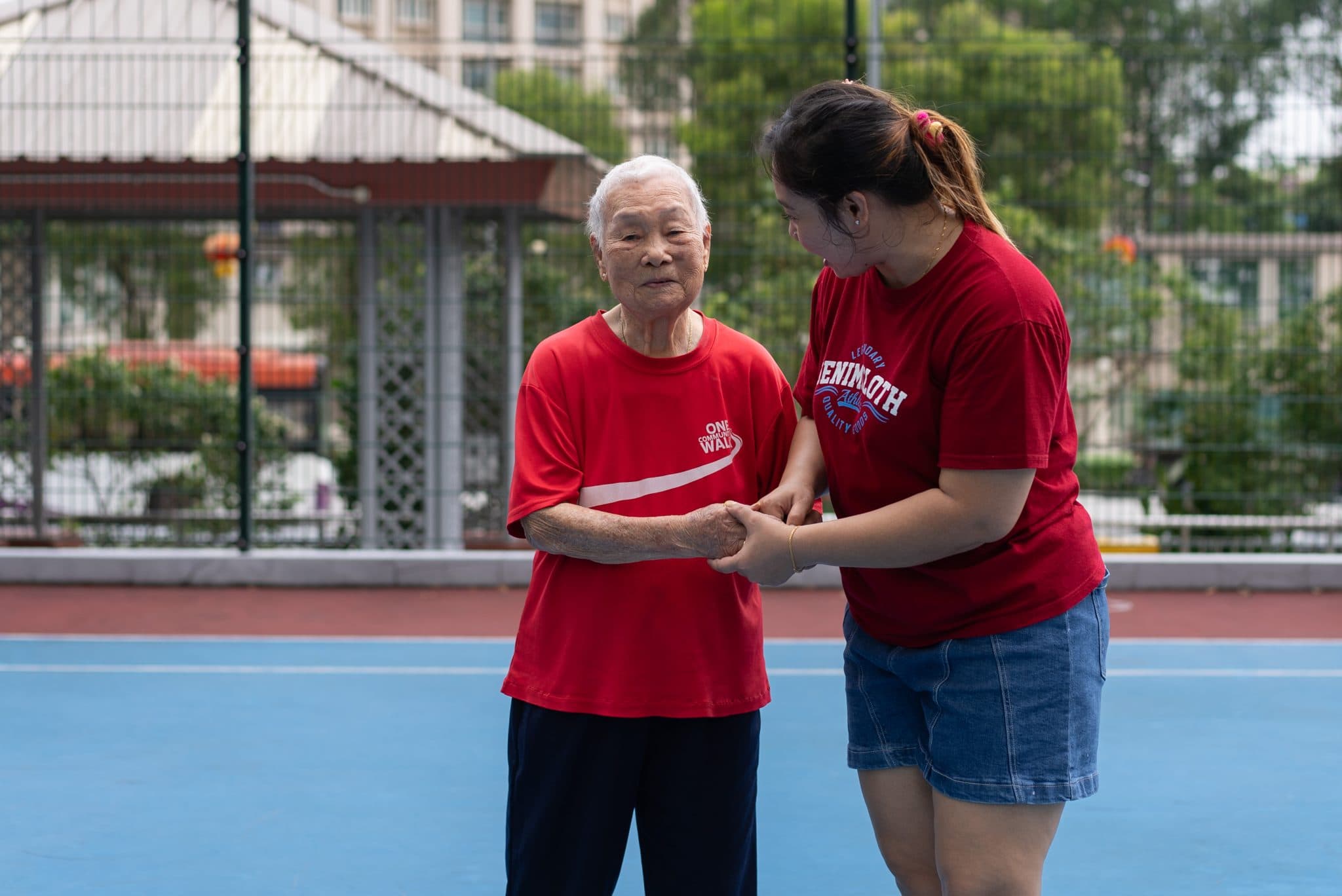 Caregiver supporting an elderly resident in a Singapore home